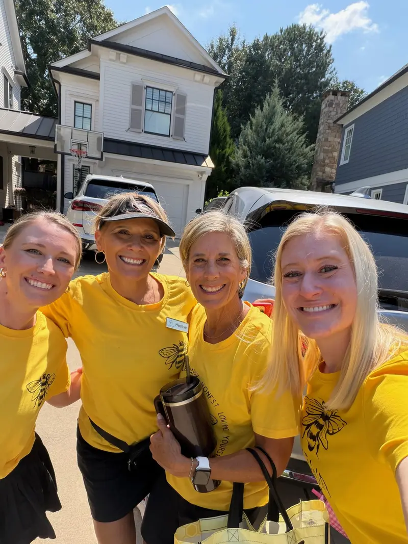Simply Busy Bee organizers in yellow team shirts taking an outdoor selfie